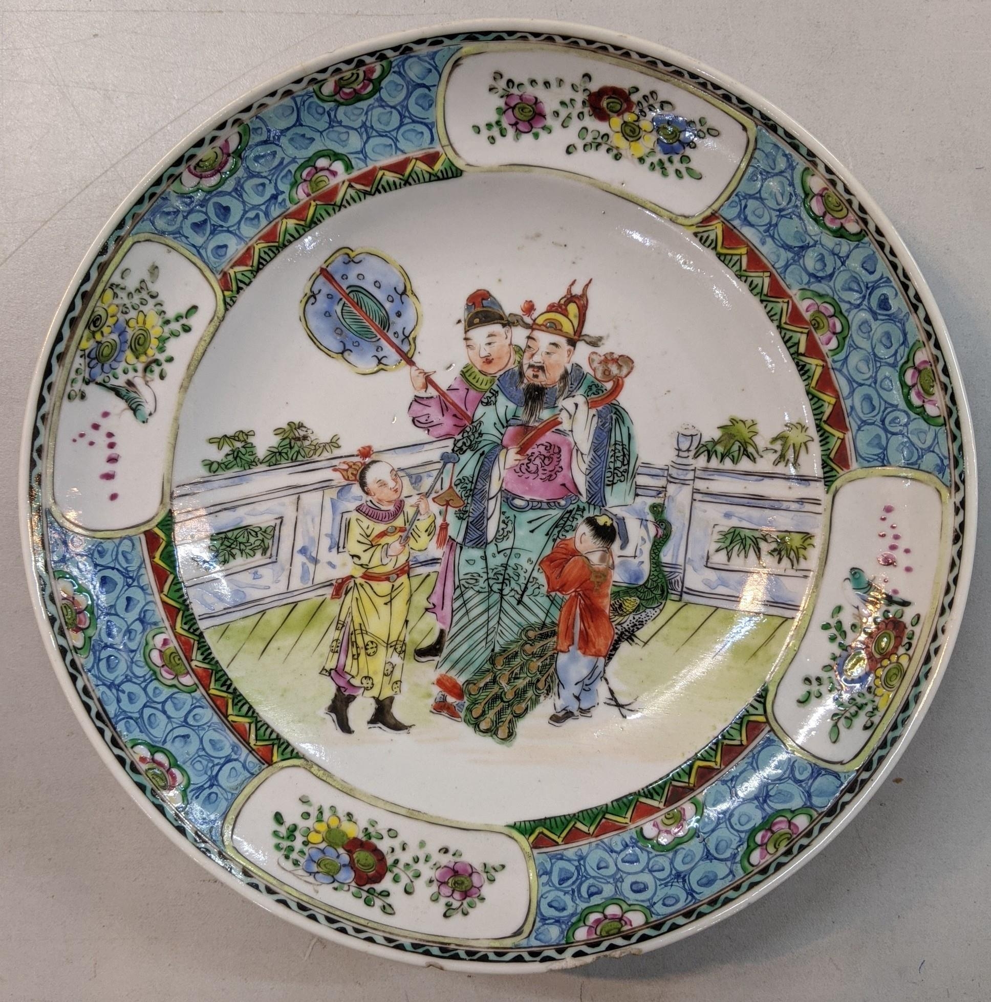 A 19th century Chinese famille rose plate having a blue border and panels decorated with birds and