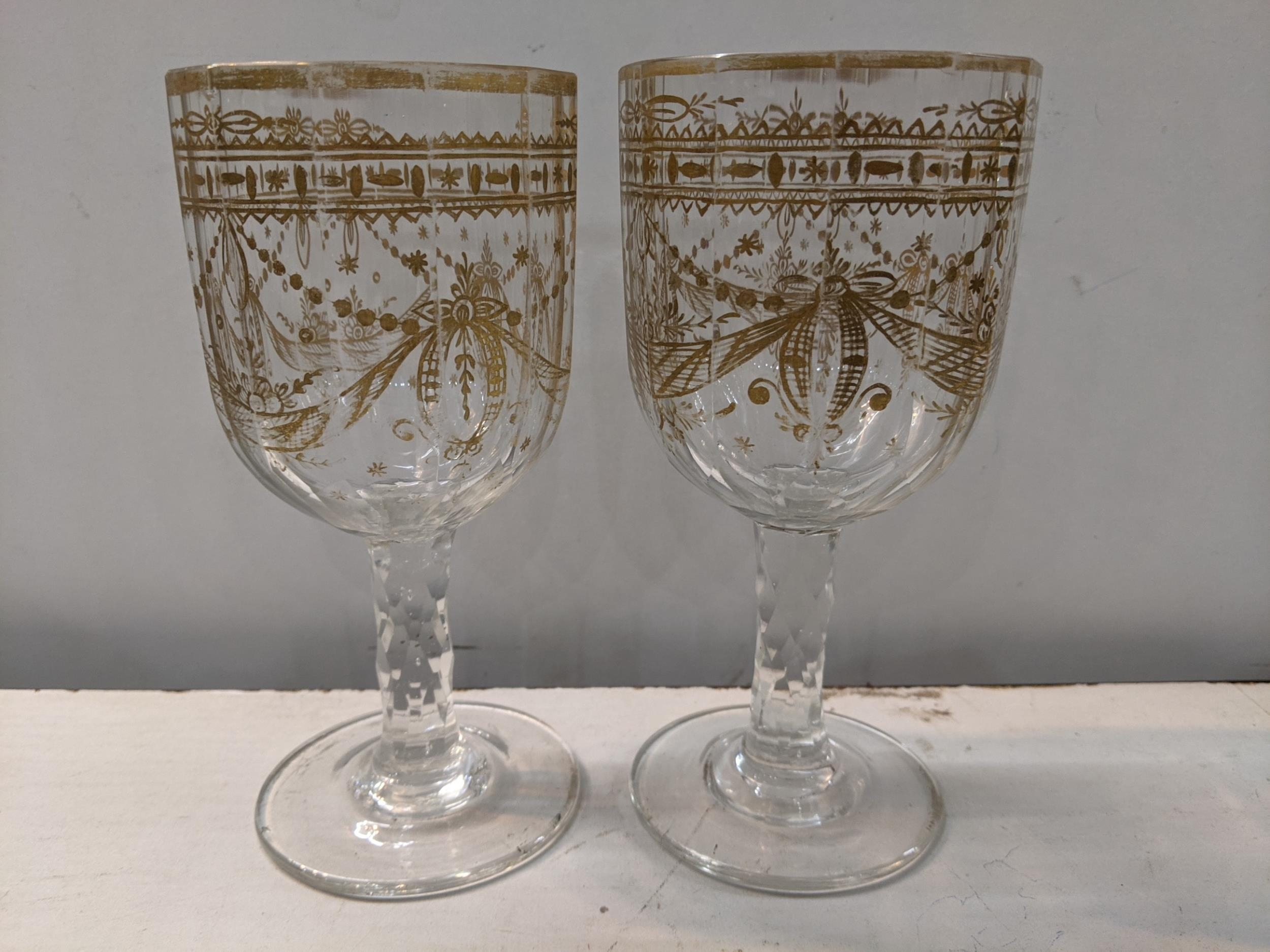 A pair of late 18th/early 19th century gilded wine glasses in the neo classical design and having