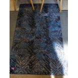 A modern rug with a mottled blue and cream pattern 147cm x 91cm Location: