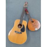 An Aria model 9504 guitar and a 20th Century flat back mandolin.