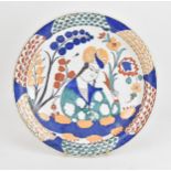 A Turkish Iznik style polychrome painted fruitware charger, designed with central figural portrait