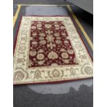 A Kendra style rug with floral decoration on a red ground. 283 x202 Location: