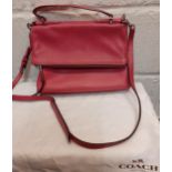 Coach-A pink leather fold-over envelope style hand bag with detachable shoulder strap and branded