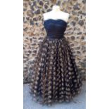 Frank Usher-A 1950's full length black netted evening gown having a full skirt with gold thread
