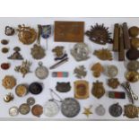 Mixed badges, coins, military buttons and medal ribbons to include a Border Regiment hat badge, a