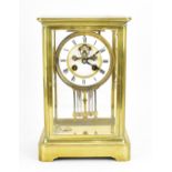 A French 19th century brass mounted four glass mantle clock, with central enamel dial with Roman