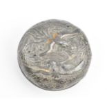 A Japanese white metal and enamel circular box, the lid with raised decoration of birds in paradise