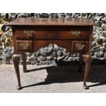A George III oak kneehole dressing table, with frieze drawer above two small dummy drawers, on