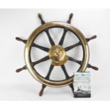 A large oak and brass ships wheel removed from HMS Royal Sovereign, the brass hub reading 'Brown