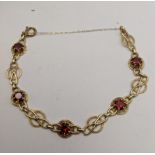 A 9ct gold bracelet set with red coloured garnets total weight 8.8g Location: