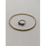 A yellow metal bangle, tested 14ct gold together with a 9ct gold ring total weight 9.8g Location: