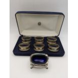 Six silver napkin rings in a fitted cased hallmarked London 1990, together with a salt pot total