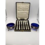 A pair of silver pierced salts together with a cased set of six silver handled butter knives.