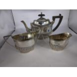 A silver three part bachelors tea set with a ribbed design comprising of a teapot, twin handled