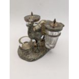 A late Victorian silver plated novelty condiment camel cruet holding two glass jars in a pannier