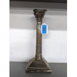 An early 20th century silver candlestick of ribbed design raised on square stepped base with