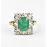 An 18ct yellow gold, emerald and diamond dress ring, with central step cut emerald in a halo of