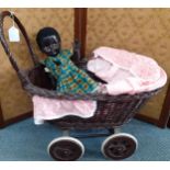 A vintage black Pedigree doll together with a painted wicker dolls pram Location: RAB