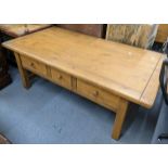 A modern pine coffee table having three drawers and on blocked shaped legs, 49H x 135W Location: