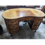 An early 20th century walnut kidney shaped dressing table, central drawer flanked by six drawers, on