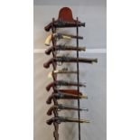 Nine reproduction flintlock style pistols with ornate decoration on a stand Location: