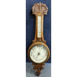 An early 20th century wall hanging Aneroid barometer in an oak carved case, 86cm h Location: