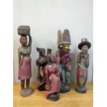 A group of five African painted and carved wooden statues to include a bearded man with a drum,