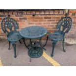 A green painted cast aluminium garden two-tier table with parasol base, and two garden chairs