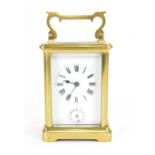 A French brass and bevelled glass cased alarm clock, with white enamel face with Roman numerals,