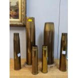 A group of WWI and WWII brass shell cases, stamped marks to bases, one without base but mounted on