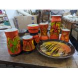 A collection of Poole pottery vases decorated in orange, yellow and red abstract patterns and