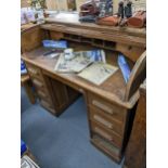 A 1930s/40s oak roll top twin pedestal desk having a fitted interior above nine drawers 101cm h x