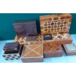 A group of walnut and parquetry cigarette and other boxes together with treen drinks mats and