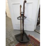 A cast iron stick stand with a horn handled walking stick and a rusticated walking stick Location:
