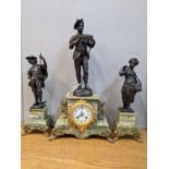 A late 19th century clock garniture surmounted by spelter figures on an onyx case and stands