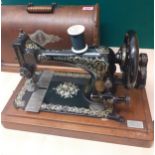 An 1873 Singer sewing machine, serial number 12036187, in a wooden case. Location:RAB