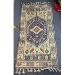 A handwoven Turkish Kazak design rug with a central symmetrical gull with repeating motifs around