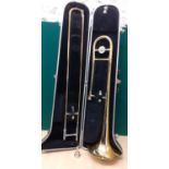 A Bundy gold tone trombone in fitted case Condition: some scratches and discolouration - see