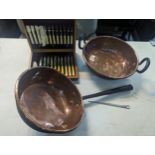 A Victorian copper preserve pan with an iron handle and a similar pan, along with knives, forks