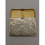 An early 20th century silver retractable stamp holder having an engraved floral case, makers mark
