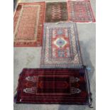 A group of four machine and handwoven scatter rugs, along with a Persian saddle style rug, various