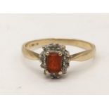 A 9ct gold cluster ring inset with an emerald cut orange coloured stone, 3g Location: