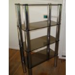 A modern smokey glass 4 shelf unit with chrome legs Location: A2M