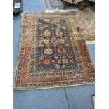 A Persian hand knotted rug with geometric and floral design on a blue ground with multi-boarders,