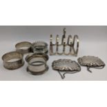 Silver to include four napkin rings and a pair of decanter labels and a toast rack 127g Location: