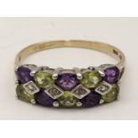 A 9ct gold ring inset with alternating purple and green stones, 2.3g Location: