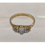 A 9ct gold ring set with an oval opal flanked by two pave stones, total weight 3.1g Location: