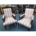 A pair of Victorian oak open armchairs with later striped upholstery and galleried sides Location: