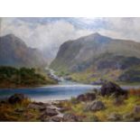 Sidney Watt (1890-1910) - a figure fishing in a loch land scene with hills and scattered boulders,