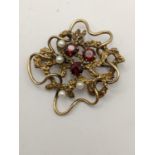 A 9ct gold brooch inset with seed pearls and red stones, 10.2g Location: